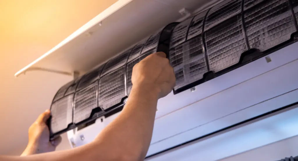 Klíma tisztítását bemutató, a szűrő kivétele közben készült kép