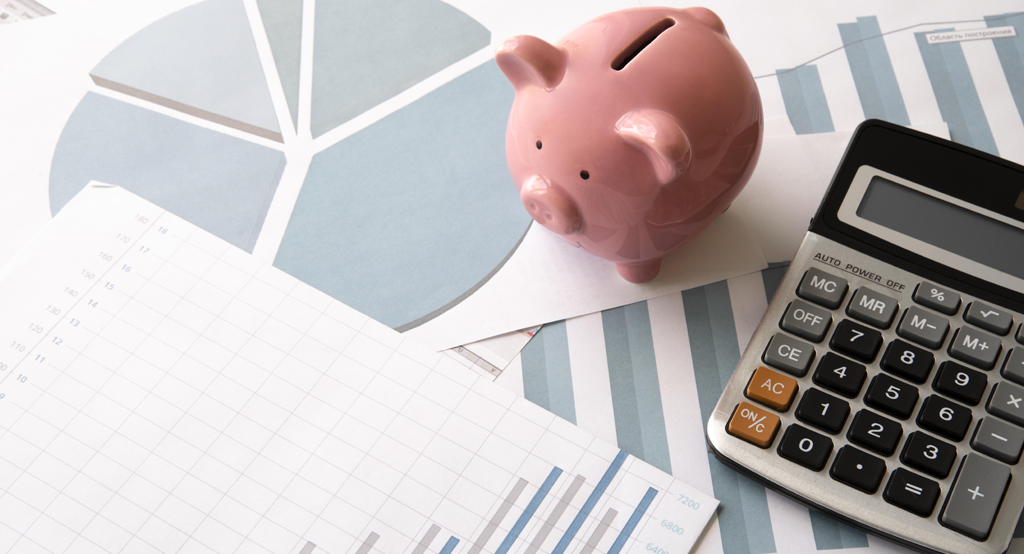 Költségkalkuláció és számológép egy malacpersellyel az asztalon